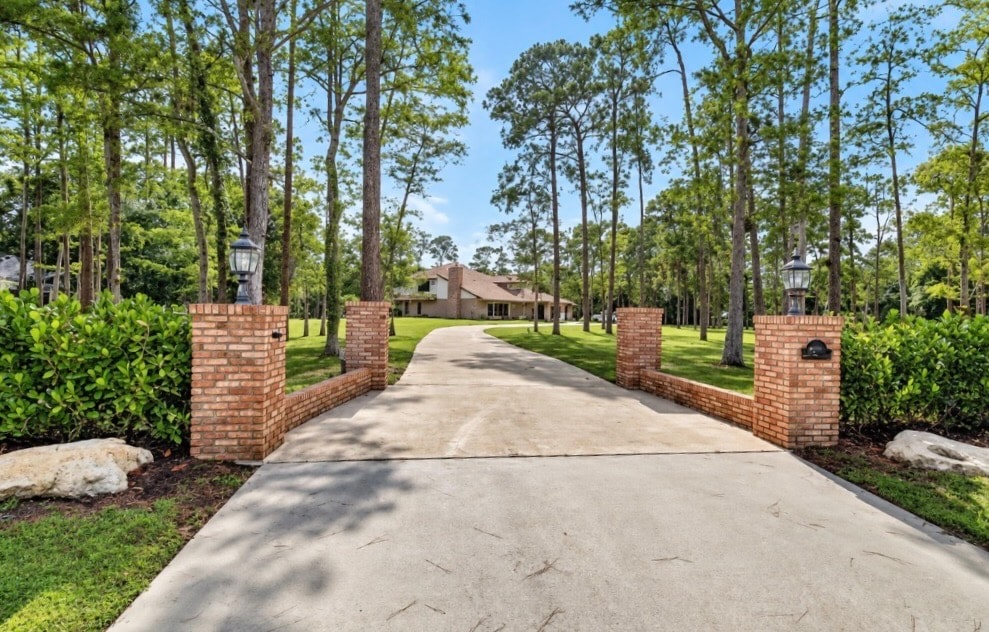 Brick pillar entrance with tree-lined driveway, luxury Wellington estate